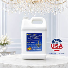 Load image into Gallery viewer, A large white plastic jug of Brillianté Clean Brilliant chandelier glass cleaner stands on a marble surface under a crystal chandelier. The jug has a blue front label with product details, and a red, white, and blue 'Made in USA' badge appears to the right.
